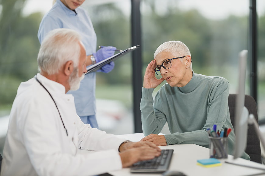 Senior Doctor Consulting with Concerned Elderly Female Patient