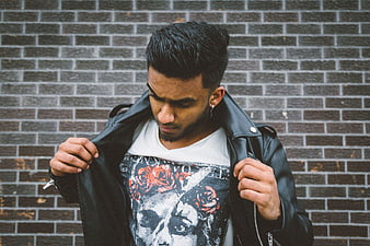 Man in Leather Jacket Against Brick Wall