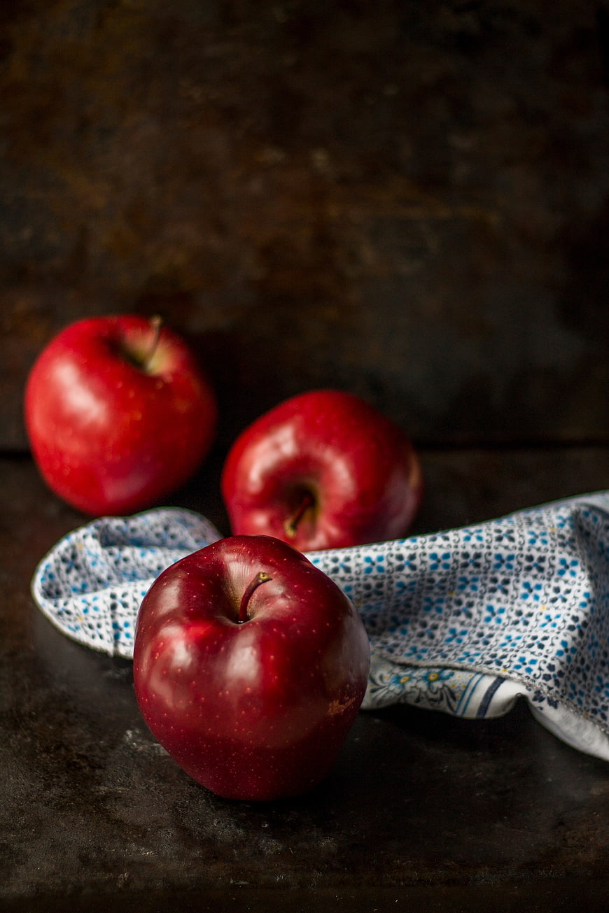 Three Red Apples on Dark Rustic Background with Cloth