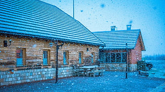 Snowy wooden cabin exterior with falling snowflakes