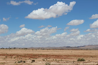 Vast desert landscape with blue sky and white clouds