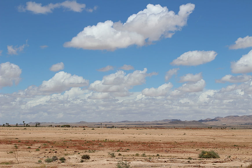 Vast desert landscape with blue sky and white clouds
