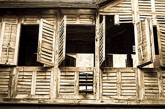 Vintage wooden shutters on old weathered building facade