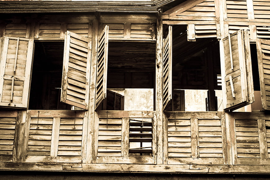 Vintage wooden shutters on old weathered building facade