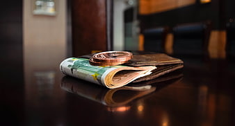 Euro banknotes and coins on a leather wallet