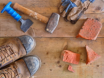 Construction tools and boots on wooden background