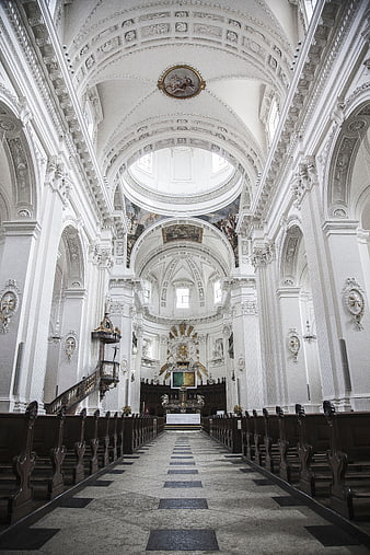 Grand white baroque church interior with ornate ceiling and altar