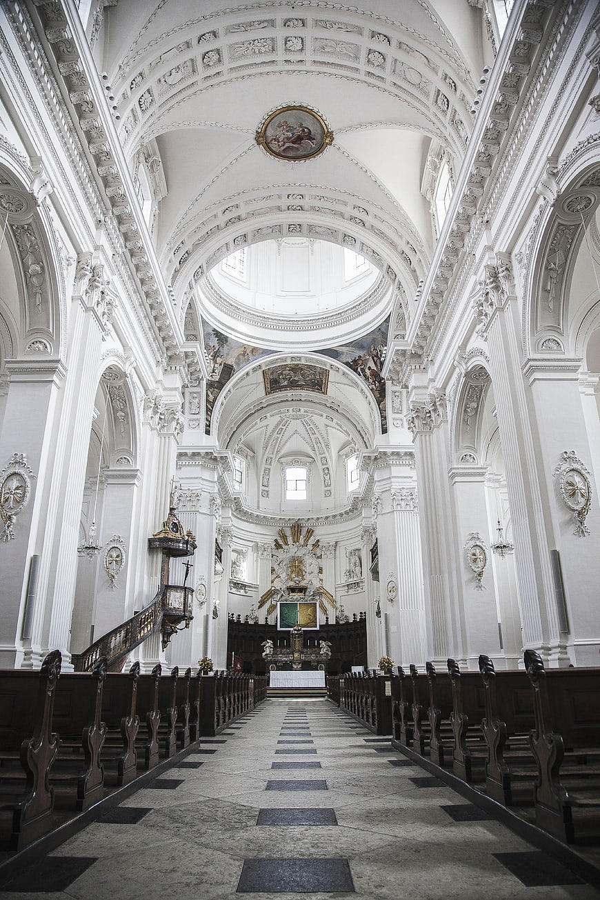 Grand white baroque church interior with ornate ceiling and altar