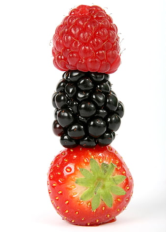 Vertical stack of fresh raspberry, blackberry, and strawberry on white background