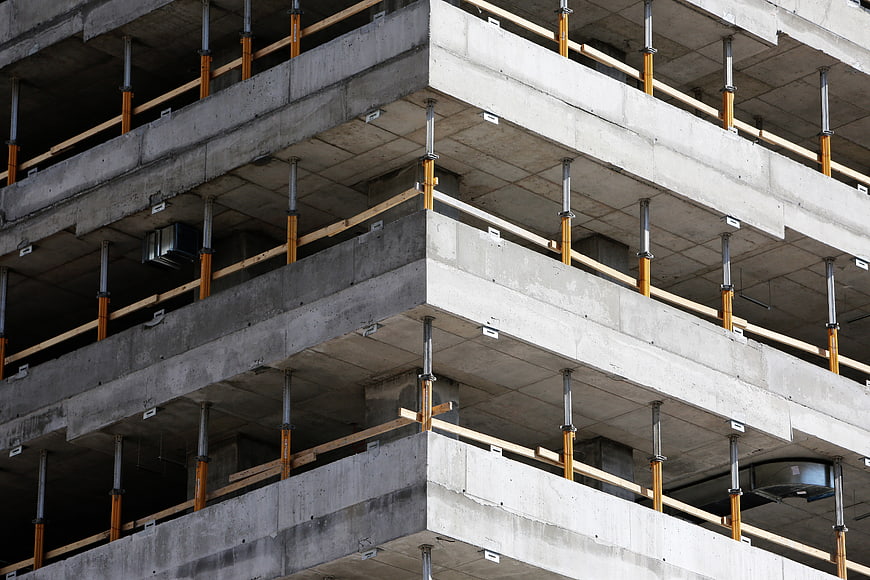Concrete building under construction with scaffolding supports