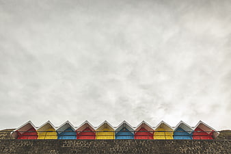 Colorful Beach Huts Row Against Overcast Sky