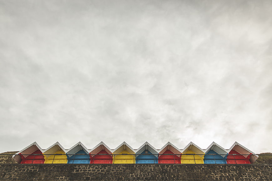 Colorful Beach Huts Row Against Overcast Sky