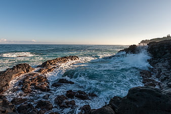 Dramatic Ocean Waves Crashing Against Rocky Coastline at Sunset