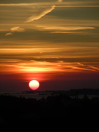 Dramatic Golden Sunset Over Silhouetted Coastal Landscape