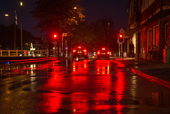 Wet City Street at Night with Red Traffic Light Reflections