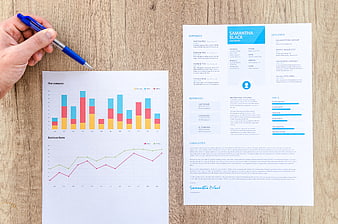 Business resume and financial charts on wooden desk