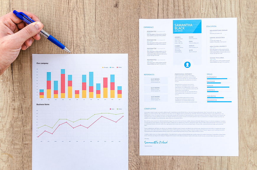 Business resume and financial charts on wooden desk