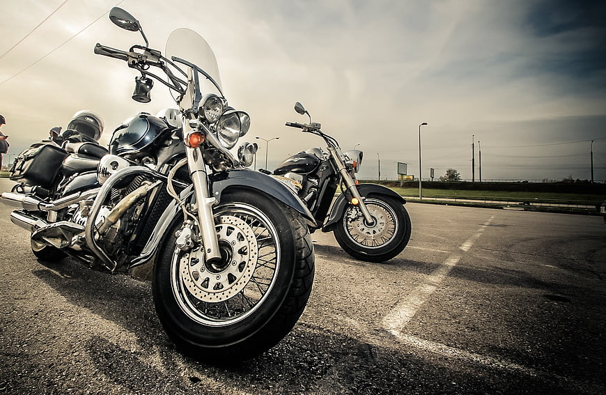 Low angle view of parked motorcycles on asphalt road