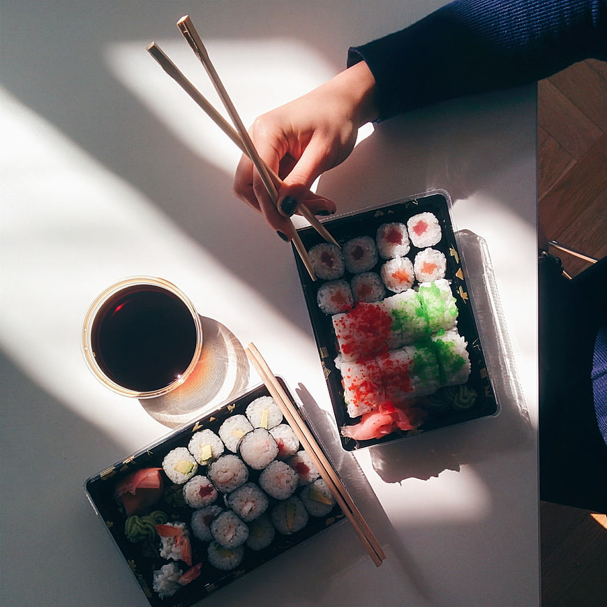 Top view of sushi takeaway boxes with chopsticks and soy sauce