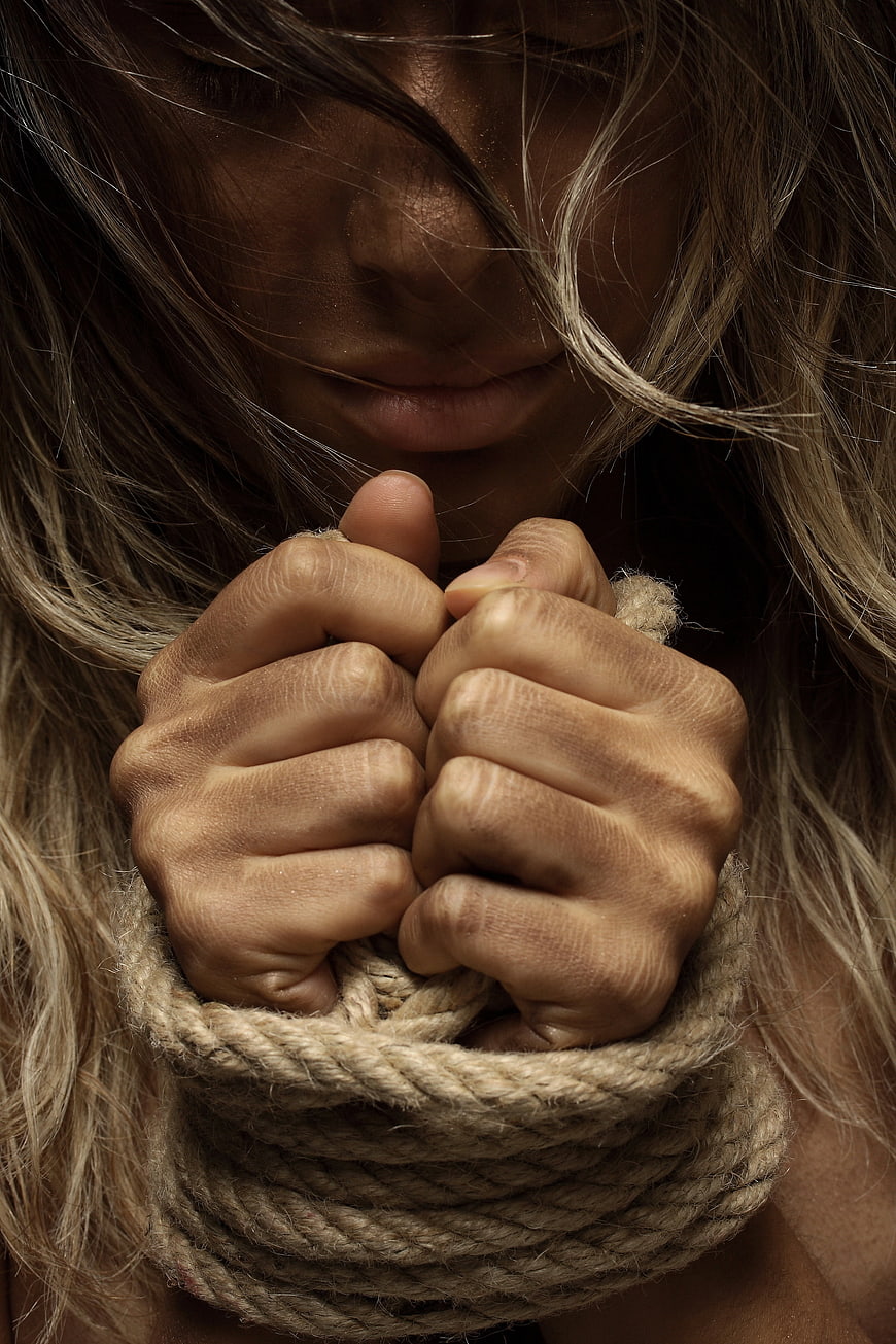 Close-up of woman with bound hands and rope