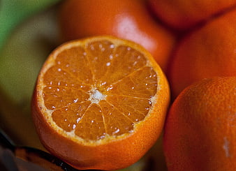 Close-up of a cut tangerine with juicy segments and fresh whole fruit