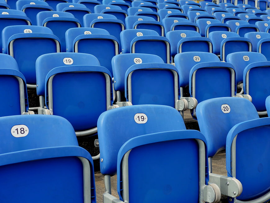 Rows of empty blue stadium seats with numbers