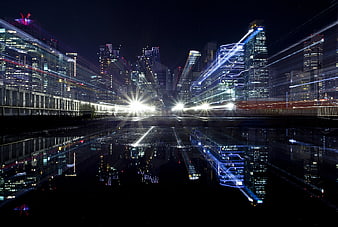 Futuristic Cityscape with Light Trails and Water Reflection