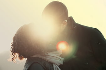 Romantic couple kissing in warm golden hour sunlight