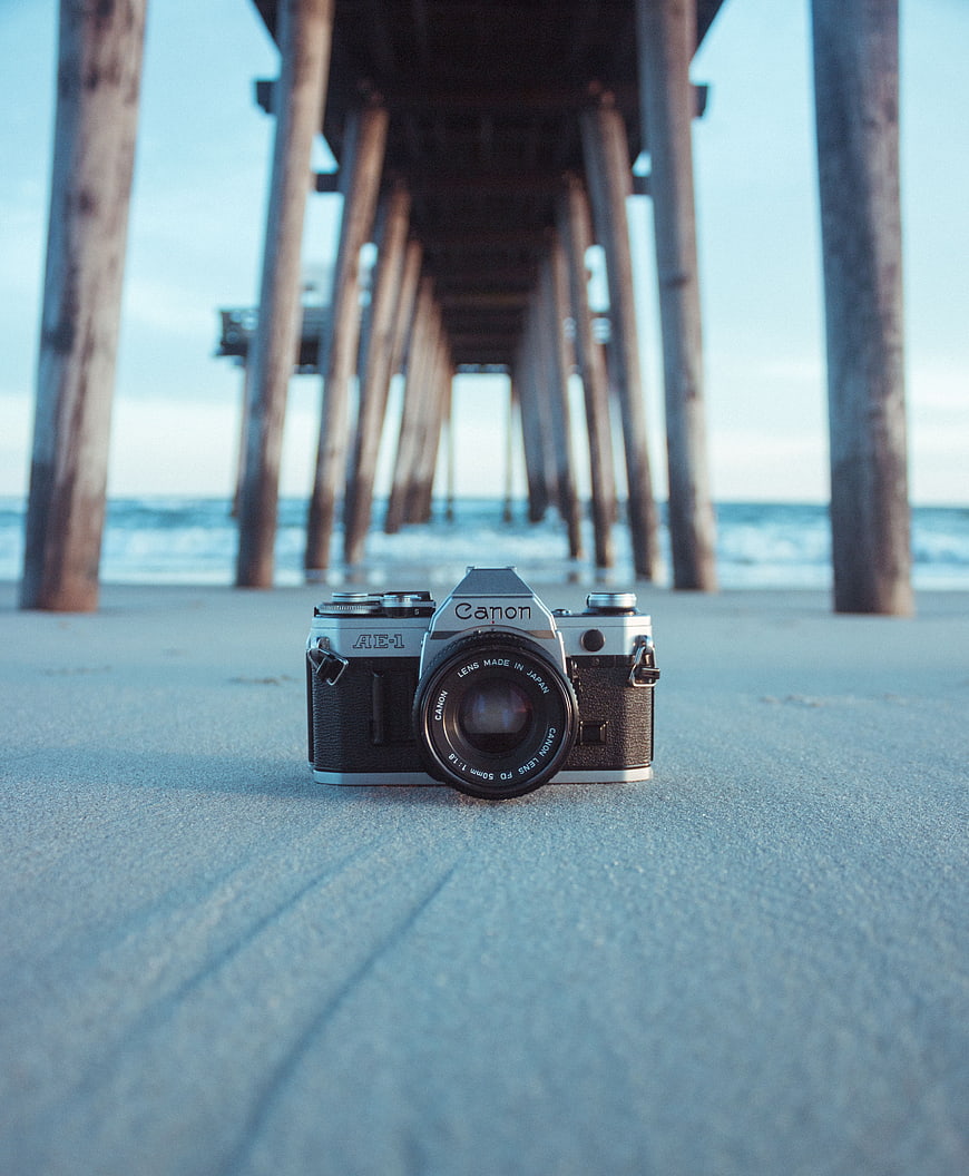 Vintage Canon AE-1 Camera on Beach Under Pier