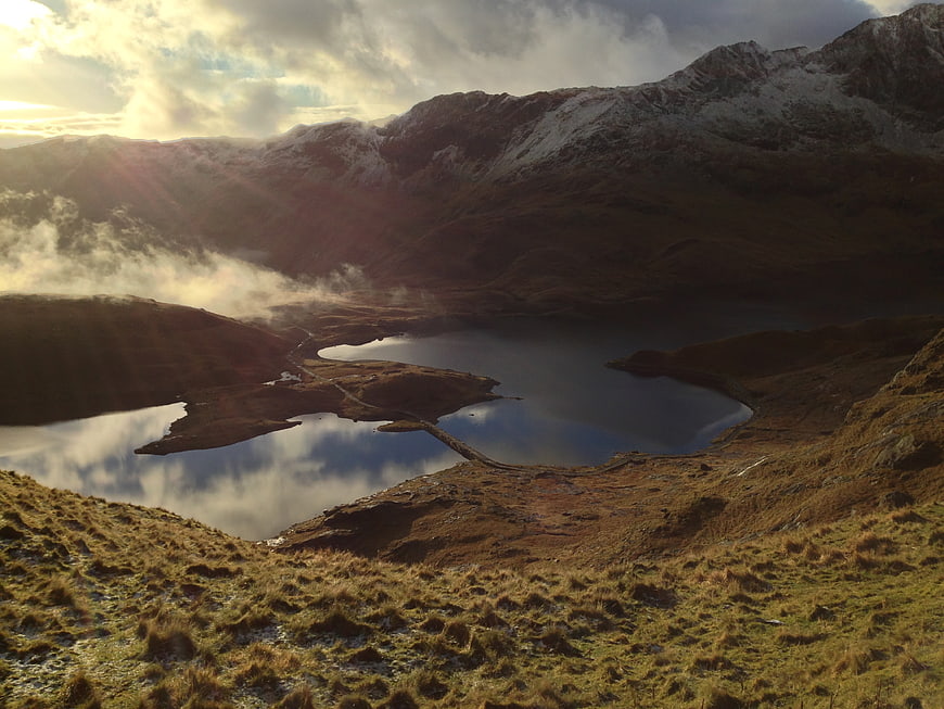 Misty Mountain Lake Landscape with Snowy Peaks and Sun Rays