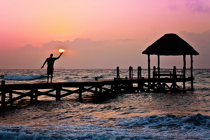 Man Silhouette Holding Sun On Ocean Pier At Sunrise