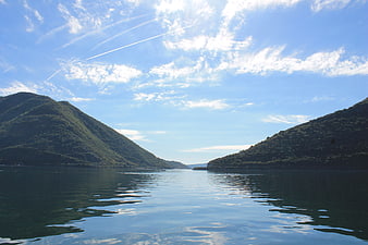 Serene Lake View Between Green Hills Under Blue Sky