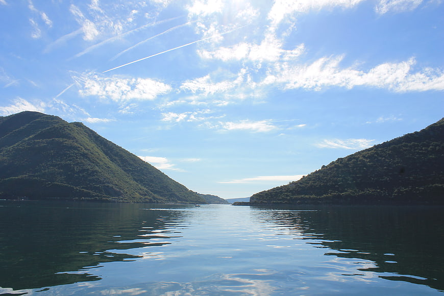 Serene Lake View Between Green Hills Under Blue Sky