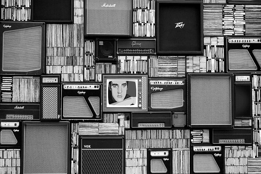 Black and white wall of vintage guitar amplifiers and vinyl records