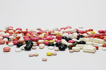 Assorted colorful pills and capsules on white background