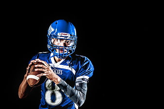 American Football Player in Blue Uniform Holding Ball