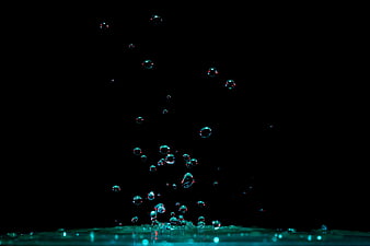 Teal Water Bubbles Rising Against Black Background