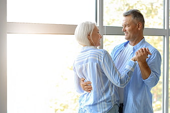 Happy Senior Couple Dancing Together Indoors by Window