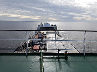 Cargo ship deck view with containers on calm ocean