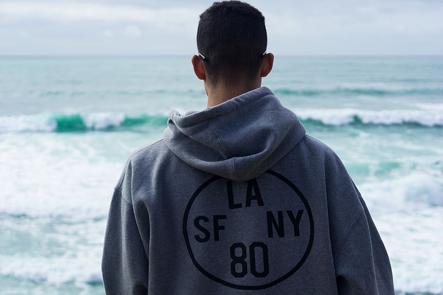Man in Grey Hoodie Looking at Ocean Waves