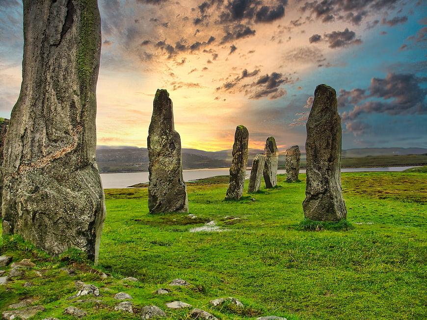 Ancient standing stones at sunset in a grassy field