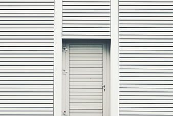 Minimalist white corrugated metal wall with door