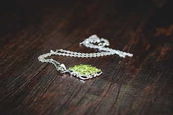 Silver Peridot Necklace on Dark Wood Background