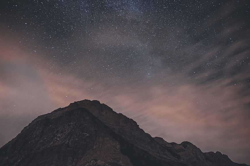 Starry Night Sky Over Mountain Peak Silhouette