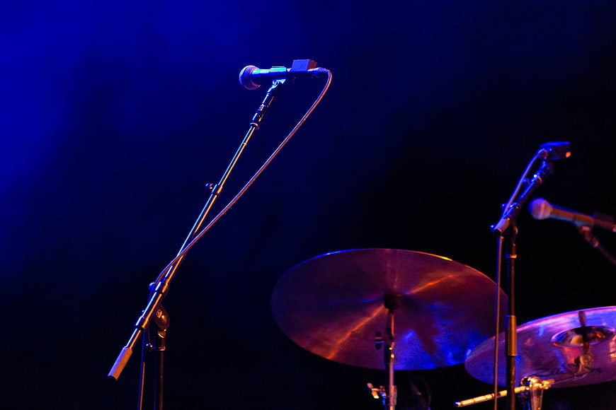 Microphone and Drum Cymbals on Dark Stage