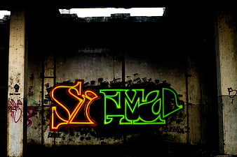 Neon graffiti art on dark concrete wall