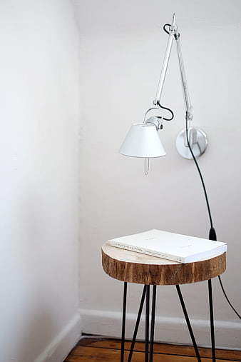 Minimalist white desk lamp and book on wooden stool