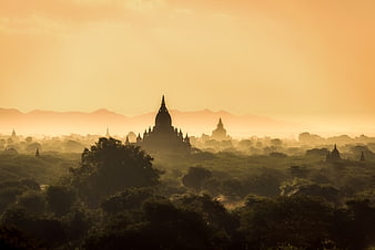 Silhouetted Pagodas in Misty Sunrise Landscape Myanmar