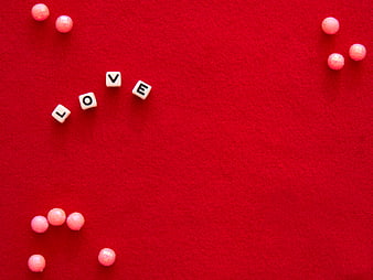 Love spelled with beads on red background