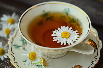 Chamomile tea in vintage porcelain cup with daisy flower